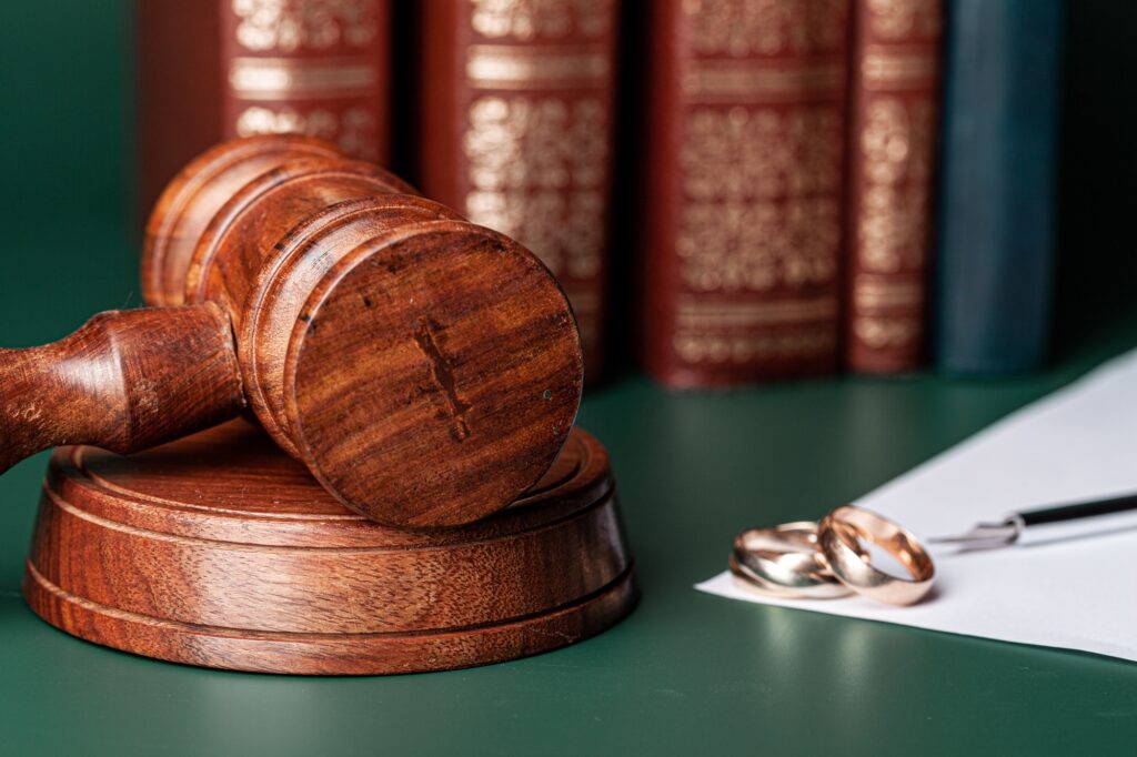Law gavel and wedding rings on table
